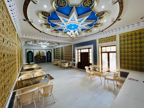 een eetkamer met een blauw en goud plafond bij Lola Boutique Hotel in Bukhara
