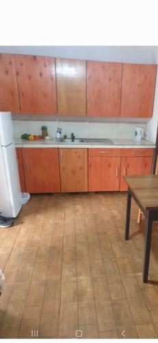 uma cozinha com armários de madeira, um lavatório e uma mesa em Wall Apartments em Hohenau