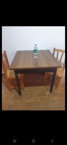 uma mesa de madeira com duas cadeiras e uma chávena em Wall Apartments em Hohenau