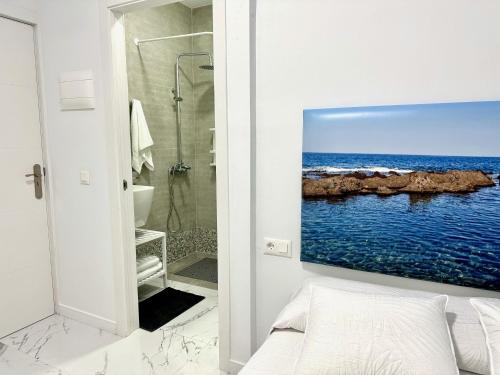 een badkamer met een afbeelding van de oceaan aan de muur bij Alcalá Retreat: Ocean View & Modern Comfort in Alcalá