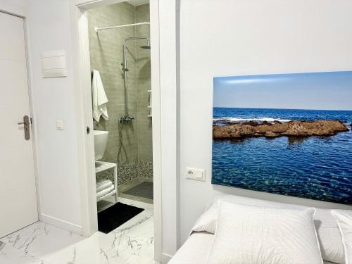 a bathroom with a picture of the ocean on the wall at Alcalá Retreat: Ocean View & Modern Comfort in Alcalá