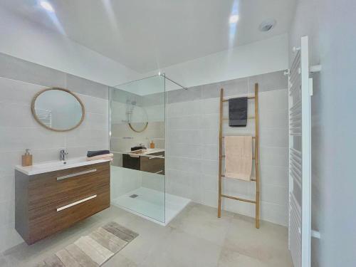 a bathroom with a shower and a sink and a mirror at APPART'ICI 3 - Spacieux appartement F3 in Lunel-Viel