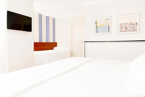 a white room with a bed and a tv at Hotel Sauce in Zaragoza