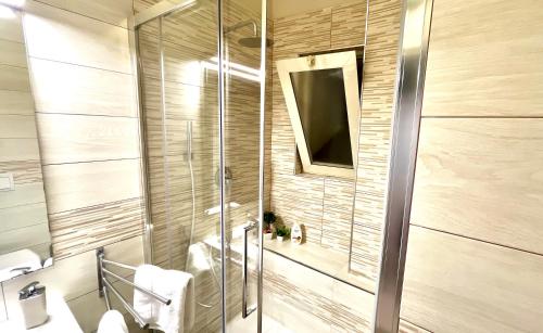 y baño con ducha, lavabo y espejo. en Archivio 32 Neapolitan Apartment, en Nápoles