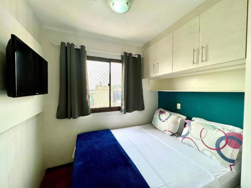 um pequeno quarto com uma cama e uma janela em Flat V. Olimpia 02 DTS, ar cond. todos ambientes em São Paulo