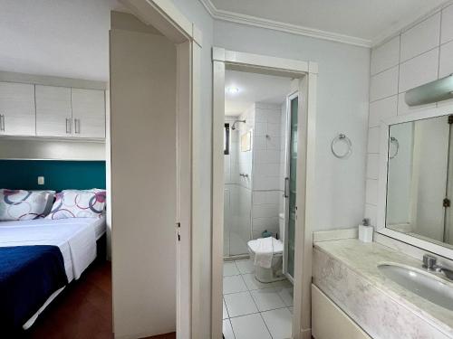 um quarto com uma cama e uma casa de banho com um lavatório em Flat V. Olimpia 02 DTS, ar cond. todos ambientes em São Paulo
