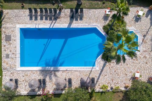 an overhead view of a swimming pool with a palm tree at Gerekos Island Apartments in Kontokali