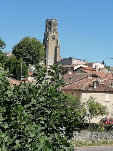 a building with a clock tower in a city at Chez Yvette & Shoji in Mauvezin