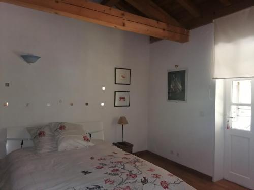 um quarto branco com uma cama e uma janela em Chez Yvette & Shoji em Mauvezin