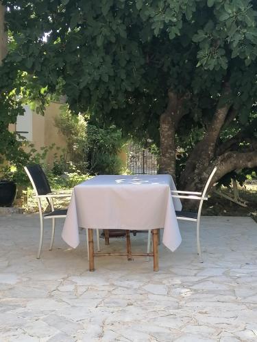 a table and two chairs with a white tablecloth on it at Chez Yvette & Shoji in Mauvezin
