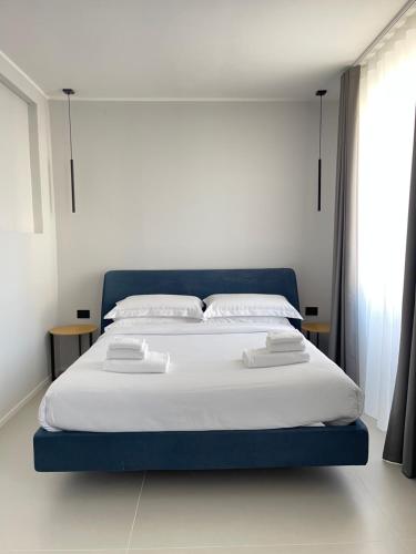 a bedroom with a large bed with white sheets and pillows at OMÍ Aparthotel in Caserta