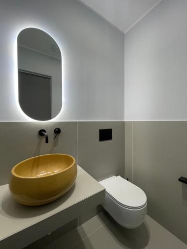 a bathroom with a wooden sink and a toilet at OMÍ Aparthotel in Caserta