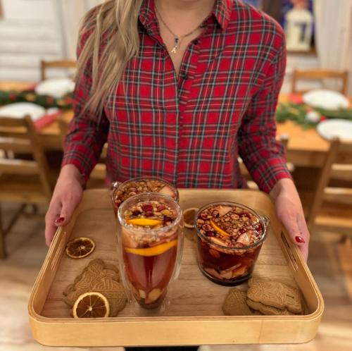 a woman holding a tray with two drinks on it at ZACISZE in Karłów