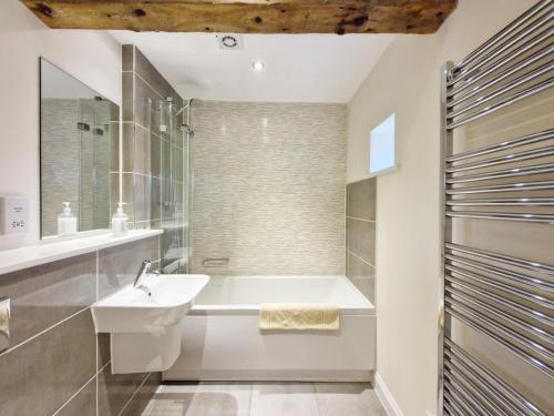uma casa de banho com um lavatório e uma banheira em The Run, West Lavant em Chichester