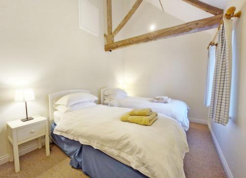 2 camas individuais num quarto com paredes brancas em The Run, West Lavant em Chichester