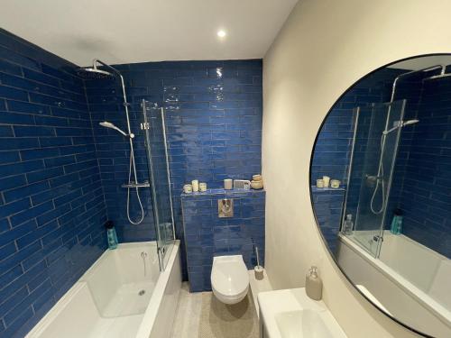 La salle de bains est pourvue de toilettes, d'une douche et d'un miroir. dans l'établissement Globe Apartments, à Glastonbury