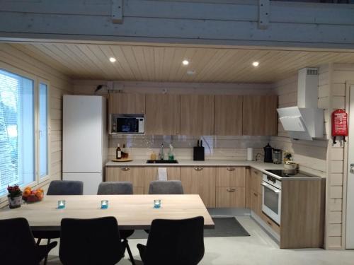 a kitchen with a table and chairs and a refrigerator at Koivuniemen Tila 3 in Säkylä