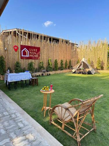 ein Hof mit einem Tisch, einem Stuhl und einem Zelt in der Unterkunft Luxe Nan Home (ลักษณ์น่านโฮม) in Ban Fai Kaeo