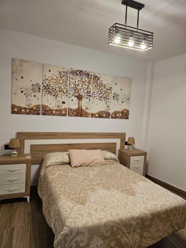 1 dormitorio con 1 cama y pinturas en la pared en Nalkia, en Villanueva de la Concepción