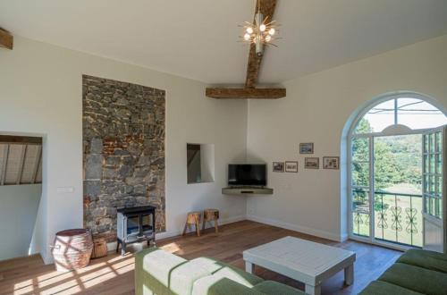 a living room with a couch and a stone fireplace at Domaine du Château de Haltinne-Maison du Jardinier in Gesves