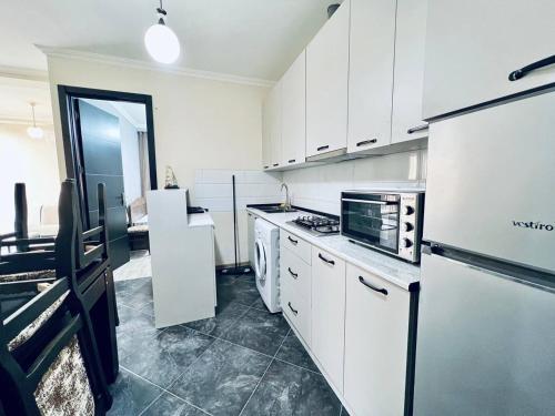 a kitchen with white cabinets and a stove top oven at Heven of Chilovski 4 in Filipów