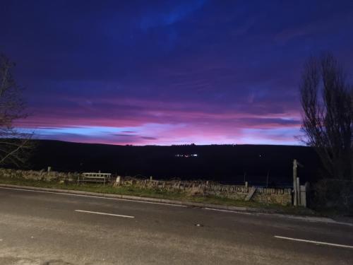 a road with a sunset in the sky at The Shady Oak B&B in Highpeak Junction
