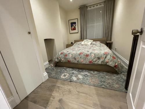 a bedroom with a bed with a floral comforter at Globe Apartments in Glastonbury