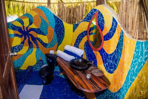 a bathroom with a wooden table with a colorful wall at Sublime Eco Hotel - Palomino Tayrona By GHO Hoteles in Palomino