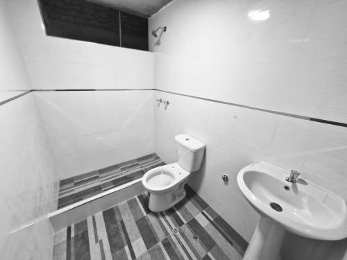 a bathroom with a toilet and a sink at La villa 3 in Cajamarca