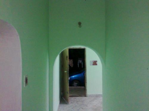 a hallway with a blue car parked in a room at Unnis Old Home in Adūr