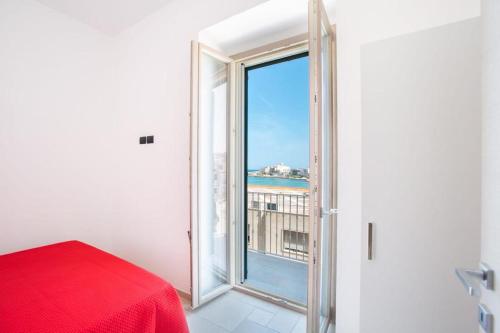um quarto com uma cama vermelha e uma grande janela em Casa Eufemia em Vieste