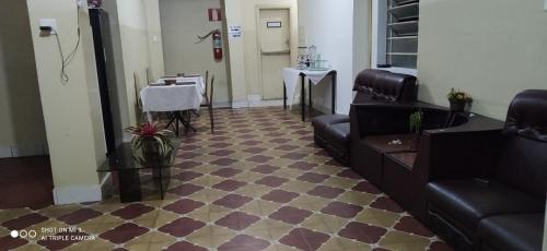 a waiting room with a couch and a table at Hotel MQ in Belo Horizonte