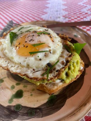 a plate with an egg on top of a sandwich at Casa Atelie Bangue in Ilhabela