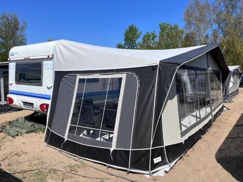 a tent is set up next to a rv at Przyczepy kempingowe Chałupy 6 KitePL - KITE & WIND & WING in Chałupy