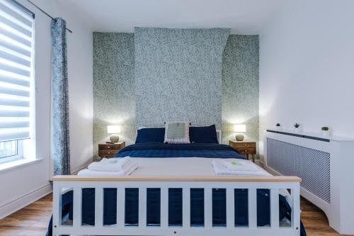 a bedroom with a bed with blue and white at 4 Bedroom Victorian House in Manchester