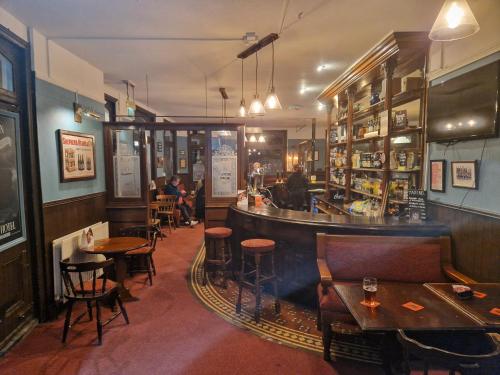 um bar num restaurante com mesas e cadeiras em Railway Hotel em Faversham