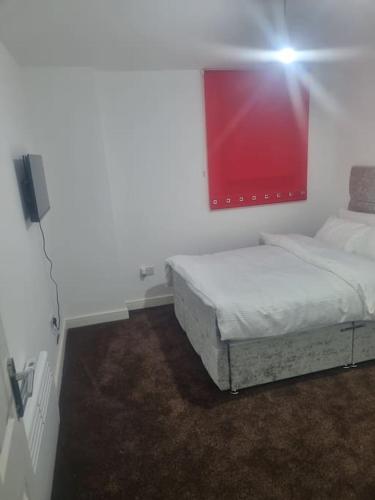 ein Schlafzimmer mit einem Bett und einem roten Gemälde an der Wand in der Unterkunft 1 Bedroom Apartment in Daventry