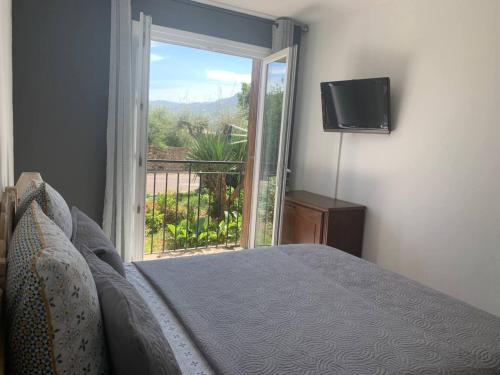 une chambre avec un lit et une grande fenêtre dans l'établissement Le Marie Louise - Bord de mer lle Rousse Calvi Est, à LʼÎle-Rousse