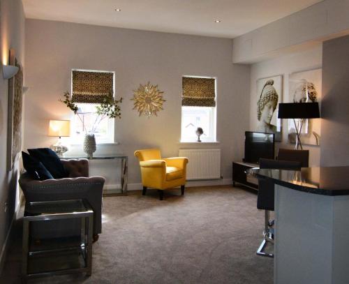 a living room with a couch and a television at The Stratford Suite Dunara 6 in Leamington Spa