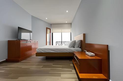 a bedroom with a bed and a dresser and a desk at Departamento para grupos grandes in Mexico City