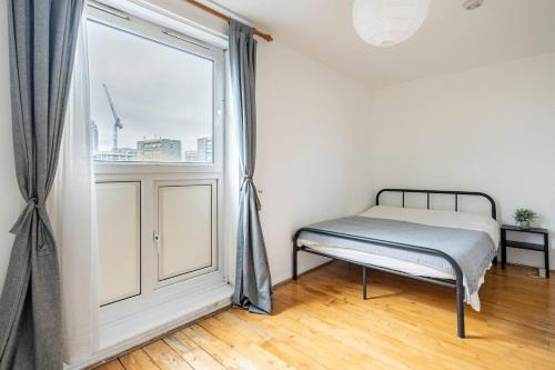 a bedroom with a bed and a large window at Spacious Room with City Skyline Views close to London Eye in London