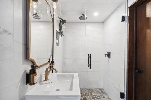 a white bathroom with a sink and a shower at 5 Bd Cabin W Private Hot Tub in Allenspark