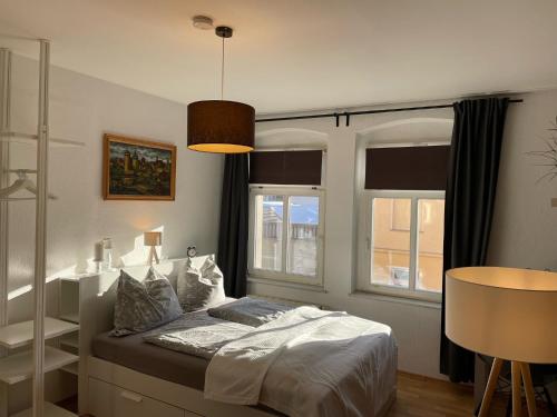 una camera con un letto e due finestre di Appartement "Stadtnest" im Zentrum von Bautzen mit WLAN und gratis Kaffee a Bautzen