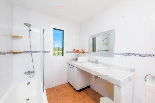 a white bathroom with a sink and a shower at Finca Sa Copinya, frente a la costa de Cala Bona in Son Servera