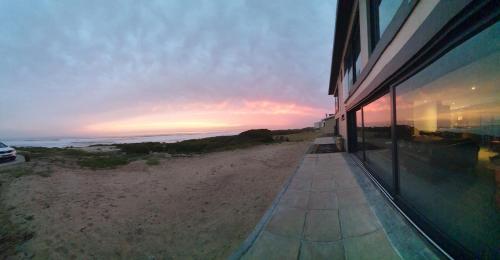 un edificio con vistas a la playa al atardecer en Marien Beach House, en Glentana