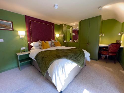 Upton的住宿－The Bittescombe Inn，一间卧室设有一张带绿色墙壁的大床