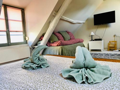 - une chambre avec un lit et deux serviettes à l'étage dans l'établissement Maison de pêcheur rénovée à 3 mn de la mer., à Cayeux-sur-Mer