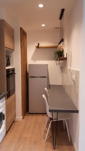 a small kitchen with a table and a refrigerator at Porticcio- Duplex dans propriété privée in Cauro