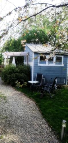 a blue house with a table and chairs in front of it at Modernes Tiny House Ortenau in Rheinau