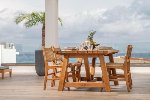 d'une table et de chaises en bois avec vue sur l'océan. dans l'établissement Porto Perla, à Kos